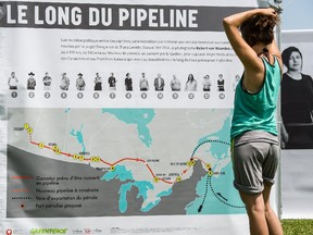 Melissa Lachance of Montreal looks at a map of the proposed Energy East pipeline, at a rally organized by Greenpeace and other groups at Jack Layton Park in Hudson on July 4, 2015.
