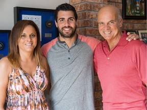 Surrounded by hockey momentoes, proud parents Joanne and Gerry Barberio, pose with their son Mark in the family dining room in Kirkland. Mark, age 25, was signed last week, to join the Montreal Canadians as a defenceman for the 2015-16 season. Growing up in Kirkland playing Lakeshore Hockey, then the AAA Lions, and the Quebec Minor Junior Hockey League, he then jumped into the NHL playing 100 games with the Tampa Bay Lightning.