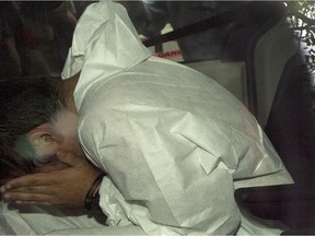 Nicholas Fontanelli hides from photographers as he arrives at the courthouse to be charged with first-degree murder of his fiancee, Samantha Higgins, Tuesday, July 14, 2015 in Montreal.