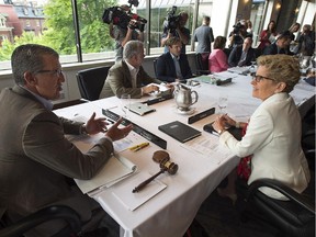 Newfoundland and Labrador Premier Paul Davis, left, chats with Ontario Premier Kathleen Wynne at the start of the summer meeting of Canada's premiers in St. John's on Thursday, July 16, 2015.