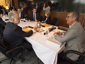 Newfoundland and Labrador Premier Paul Davis, right, chats with Quebec Premier Philippe Couillard at the summer meeting of Canada's premiers in St. John's on Friday, July 17, 2015.