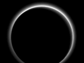 Backlit by the sun, Pluto's atmosphere rings its silhouette like a luminous halo in this image taken by NASA's New Horizons spacecraft around July 15, and released July 23, 2015.