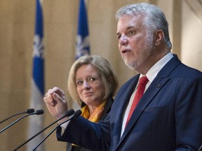 Quebec Premier Philippe Couillard responds to reporters questions as Alberta Premier Rachel Notley looks on, Tuesday, July 14, 2015 at a joint news conference in Quebec City.
