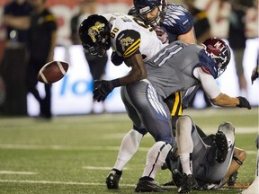 Hamilton Tiger-Cats wide receiver Terrence Toliver (80) fumbles as he is tackled by Montreal Alouettes linebacker Chip Cox (11) during fourh quarter CFL action Thursday, July 16, 2015 in Montreal.