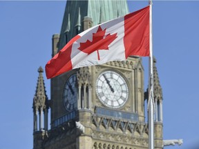 The Canadian flag flies in front of the Peace Tower on Parliament Hill in Ottawa.