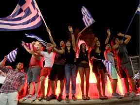 People celebrate in front of the Greek parliament as the people of Greece reject the debt bailout by creditors on July 6, 2015.
