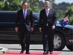 Australian Prime Minister Tony Abbott (left) walks with Canadian Prime Minister Stephen Harper as he arrives on Parliament Hill in Ottawa, Monday June 9, 2014.