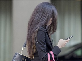 A pedestrian walks through the streets of Toronto while communicating on  a cell phone, Thursday April 16, 2015.