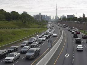 Vehicles travel along the nearly-empty Pan Am high-occupancy vehicle lanes as morning rush hour traffic crawls in Toronto on Monday, June 29, 2015.