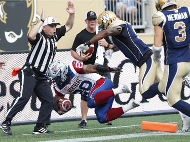 Montreal Alouettes' Tyrell Sutton (20) just gets his foot over the line as Winnipeg Blue Bombers' Chris Randle (8) attempts to push him out of bounds during the first half of CFL action in Winnipeg Friday, July 10, 2015.