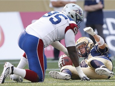 Winnipeg Blue Bombers quarterback Drew Willy (5) gets sacked by Montreal Alouettes' Corvey Irvin (95) during the first half of CFL action in Winnipeg Friday, July 10, 2015.