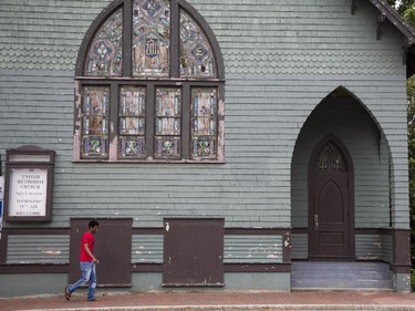 A pedestrian walks past the historic Winooski United Methodist Church in Winooski, Vermont, Saturday June 27, 2015. The little town in the shadow of Burlington is quickly becoming a hot spot for food and drink.