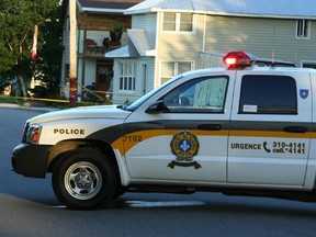 Photos by : Roger Collier
¤
Police barricaded the home behind the police vehicle at right.  Sûreté du Québec officers outside the Shawville home of 33-year-old Sandy Smart. Mr. Smart was hot by an officer after a 10-hour standoff.