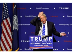 Republican presidential candidate Donald Trump pulls his hair back to show that it is not a toupee while speaking during a rally at the TD Convention Center, Thursday, Aug.  27, 2015, in Greenville, S.C. Trump says his trademark hairdo is for real. He told 1,800 people in South Carolina Thursday: "It's my hair ... I swear." (AP Photo/Richard Shiro)