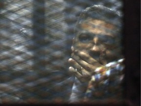 Canadian Al-Jazeera English journalist Mohammed Fahmy, listens to his verdict in a soundproof glass cage inside a makeshift courtroom in Tora prison in Cairo, Egypt, Saturday, Aug. 29, 2015. An Egyptian court on Saturday sentenced three Al-Jazeera English journalists, including Fahmy, to three years in prison, the last twist in a long-running trial criticized worldwide by press freedom advocates and human rights activists.