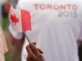 A fan waves the Canadian flag at the Parapan Am Games torch relay at Jane Forrester Park in Belleville, Ont. Tuesday, August 4, 2015. The games run Aug. 7-15 in Toronto.