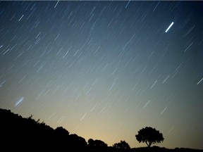 A meteor streaks across the sky against a field of stars during a meteorite shower early August 13, 2010 near Grazalema, southern Spain.