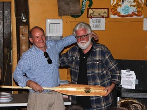 Andrew Caddell, left, presenter of the Pip Award, with The Montreal Gazette's Terry Mosher, recipient of the eighth Pip award, on Aug. 8, 2015, in the dining hall of the YMCA's Camp Kanawana in St-Sauveur, where the ceremony took place. They are holding the award, which is in the form of a paddle.