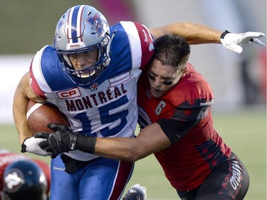 Montreal Alouettes' Samuel Giguere (15) gets tackled by Ottawa Redblacks' Antoine Pruneau (6) during the first half of a CFL game in Ottawa on Friday, Aug. 7, 2015.