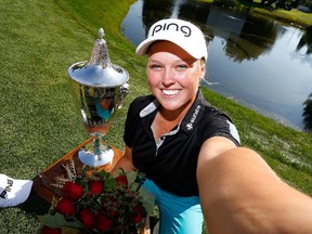 PORTLAND, OR - AUGUST 16:  Brooke Henderson of Canada imitates a selfie with the trophy after her 21 strokes under par victory during the final round of the LPGA Cambia Portland Classic at Columbia Edgewater Country Club on August 16, 2015 in Portland, Oregon.