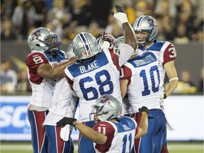 Alouettes players celebrate a late-game interception by linebacker Kyries Hebert late in the game to seal a victory against the Tiger-Cats in Hamilton on Thurs., Aug. 27, 2015.