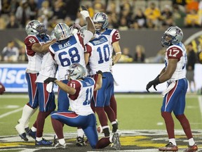 Montreal Alouettes players celebrate a late-game interception by teammate linebacker Kyries Hebert (34) in the second half of CFL football action in Hamilton on Thursday, August 27, 2015. The Hamilton Tiger Cats lost 26-23 for the first time at home at Tim Horton's Field.
