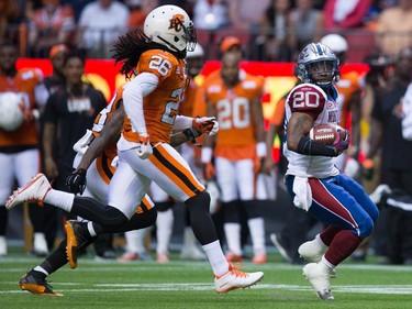 Montreal Alouettes' Tyrell Sutton (20) looks back at B.C. Lions' Cord Parks (26) as he runs for a first down during the first half of a CFL football game in Vancouver, B.C., on Thursday August 20, 2015.