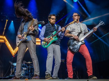 Left to right: Brian Bell, Rivers Cuomo, and Scott Shriner of the rock band Weezer perform on the second day of the 2015 edition of the Osheaga music festival at Jean-Drapeau park in Montreal on Saturday, August 1, 2015.