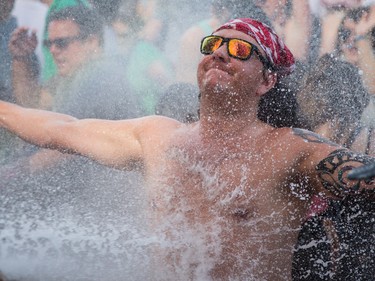 MONTREAL, QUE.: AUGUST 2, 2015 -- A music fan is sprayed by a water hose during the performance by Future Islands performs on the third day of the 2015 edition of the Osheaga music festival at Jean-Drapeau park in Montreal on Sunday, August 2, 2015.