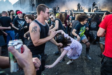 Music fans dance in a mosh pit during the performance by Norwegian musician Abbath (Olve Eikemo) on day two of the Heavy Montreal music festival at Jean-Drapeau park in Montreal on Saturday, August 8, 2015.