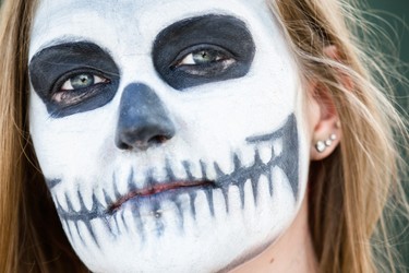 Music fan Ka from Ottawa poses for a photograph to show her face paint on day two of the Heavy Montreal music festival at Jean-Drapeau park in Montreal on Saturday, August 8, 2015.