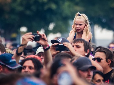 A young girl in the crowd covers her ears during the performance by American band Testament on day two of the Heavy Montreal music festival at Jean-Drapeau park in Montreal on Saturday, August 8, 2015.