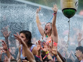 A music fan is sprayed with water during the performance by the Dutch DJ duo Showtek at the IleSoniq music festival in Montreal Aug. 15, 2015.