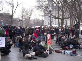 Demonstrators sit on the street at an anti-austerity protest, Thursday, March 26, 2015 in front of the legislature in Quebec City.