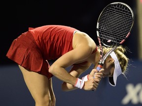 Eugenie Bouchard, of Canada, hits her racquet on the ground after being broken in the third set against Belinda Bencic, of Switzerland, during tennis action at Rogers Cup in Toronto on Tuesday, August 11, 2015.