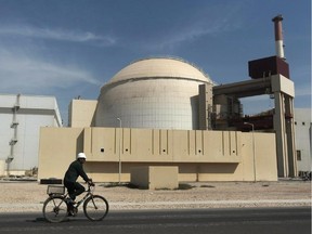 A worker rides a bicycle in front of the reactor building of the Bushehr nuclear power plant, just outside the southern city of Bushehr, Iran.