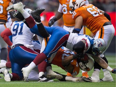 Montreal Alouettes' Gabriel Knapton and B.C. Lions' Rolly Lumbala, bottom, collide during the first half of a CFL football game in Vancouver, B.C., on Thursday August 20, 2015.
