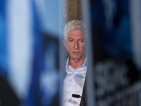 Bloc Quebecois Leader Gilles Duceppe is seen through campaign posters as he addresses supporters during a campaign stop Tuesday, August 18, 2015 in St-Jerome, Que.