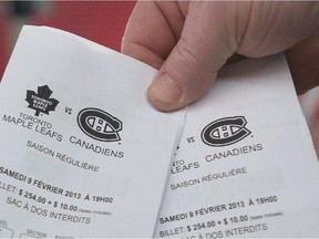 A man holds up tickets prior to an NHL hockey game.