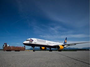 A tug decorated like a Viking ship tows an Icelandair Boeing 757 to a gate at Vancouver International Airport, May 14, 2014.