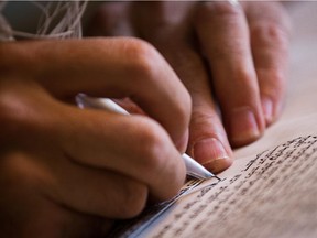 Jamie Shear works on a Torah scroll at his workshop at the Jerusalem Fifth Quarter art gallery in Jerusalem's Old City on June 30, 2015. Shear is a professional scribe and artist who specializes in several forms of calligraphy.