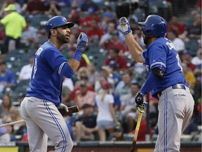 Toronto Blue Jays' Jose Bautista, left, celebrates his two-run home run against the Texas Rangers with teammate Chris Colabello during the third inning of a baseball game, Tuesday, Aug. 25, 2015, in Arlington, Texas.