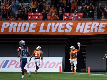 B.C. Lions' Ryan Phillips (21) turns to celebrate with teammate Josh Johnson (23) as he scores a touchdown after intercepting a Montreal Alouettes pass during the first half of a CFL football game in Vancouver, B.C., on Thursday August 20, 2015.