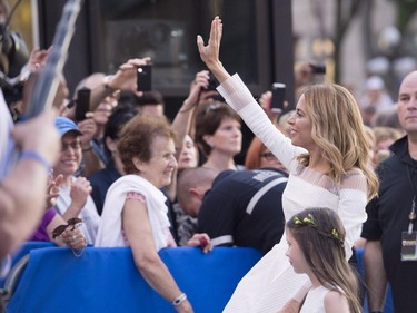 Julie Snyder and her daughte, Romy, wave to the crowd as she arrives to marry to Parti Québécois Leader Pierre-Karl Peladeau, Saturday, August 15, 2015, in Quebec City.