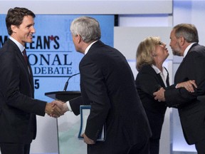 Liberal leader Justin Trudeau, left, shakes hands with Conservative leader Stephen Harper as Green party leader Elizabeth May and NDP leader Thomas Mulcair embrace following the first leaders debate Thursday, August 6, 2015 in Toronto.