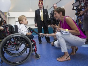Kaleb-Wolf De Melo Torres, who has brittle bone disease, is interviewed by CTV Montreal reporter Cindy Sherwin in a play area of  as Jerry Gant, Imperial Potentate Shriners International looks on. at the new $127-million Shriners Hospital for Children Thursday, August 20, 2015.