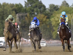 Keen Ice, left, with Javier Castellano, moves past Frosted, centre, with Joel Rosario, and Triple Crown winner American Pharoah, with Victor Espinoza, to win the Travers Stakes horse race at Saratoga Race Course in Saratoga Springs, N.Y., Saturday, Aug. 29, 2015.