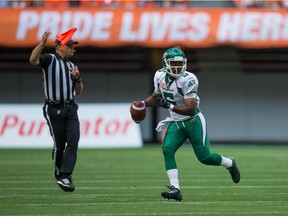 An official throws a penalty flag as Saskatchewan Roughriders quarterback Kevin Glenn looks for an open receiver during CFL game against the B.C. Lions in Vancouver on July 10, 2015.
