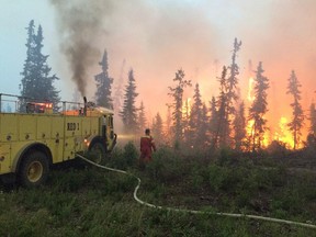 A fire crew battles a blaze in the La Ronge area on northern Saskatchewan, Saturday, July 4, 2015.