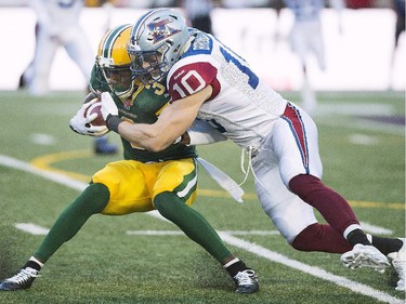 Montreal Alouettes' Marc-Olivier Brouillette, right, tackles Edmonton Eskimos' Wallace Miles during first half CFL football action in Montreal, Thursday, August 13, 2015.
